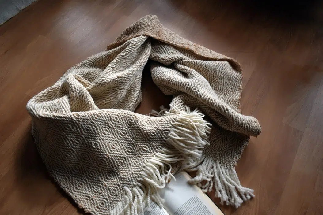 piecera tejida, Piecera tejida a telar piecera en colores muy claros, blanco y beige suave ,esta extendida ensuelo, mostrando los dos diseños ya que es reversible, tienes unos rombos muy discreto en todo el producto