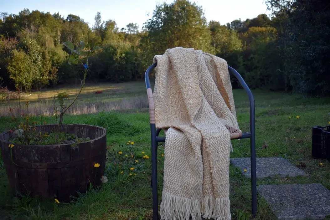 piecera de lanada, Piecera tejida a telar piecera en colores muy claros, blanco y beige suave ,esta extendida ensuelo, mostrando los dos diseños ya que es reversible, tienes unos rombos muy discreto en todo el productoda, Piecera tejida a telar piecera en colores muy claros, blanco y beige suave ,esta al aire libre sobre una silla, mostrando los dos diseños ya que es reversible, tienes unos rombos muy discreto en todo el producto