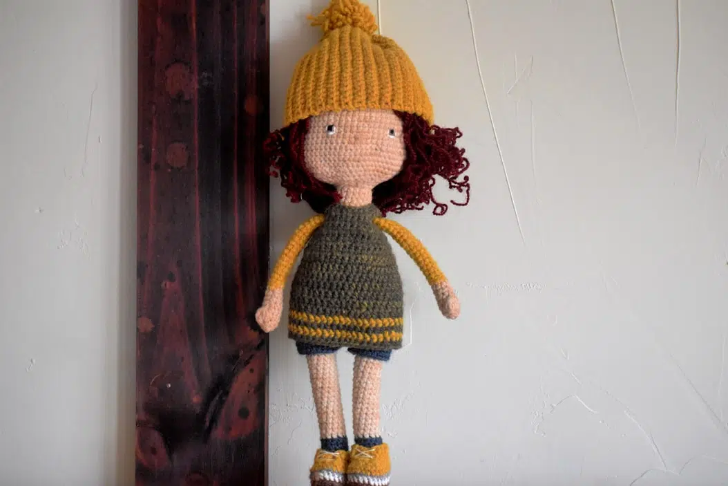 Amigurumi Juguete Tejido a crochet, con un vestido verde y unas lineas amarillas, sus zapatillas hacen juego, ya que son amarillas y un gorro