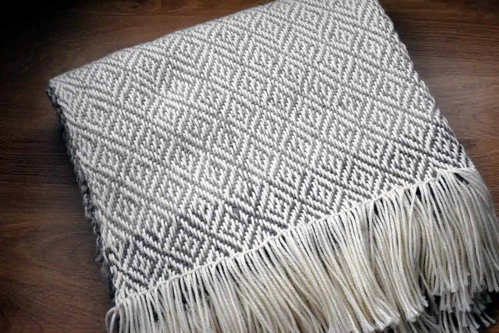 Piecera Super King en lana natural con diseño de rombos hecho a mano